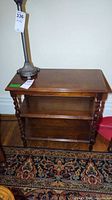 Full view of three-tier side table with lamp atop
