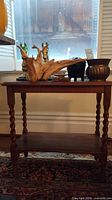 Full view of two-tier wooden end table with items on top
