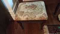 overall view of footstool showing wood frame and upholstery