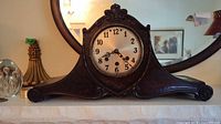 front view of entire mantel clock on shelf