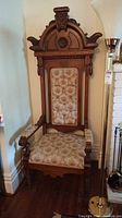 Full view of carved high-back oak armchair with upholstery
