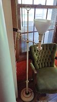 Full view of floor lamp beside chair showing height and overall design