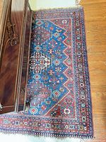 Full rug partially under furniture showing overall size and pattern