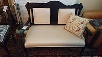 Front view of loveseat showing wood frame, upholstery, pillow