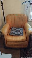 Front view of upholstered armchair with pillow