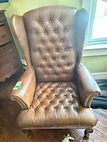 Front view showing leather upholstery, tufted back and seat
