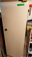 Front view of closed white cabinet with single door and knob
