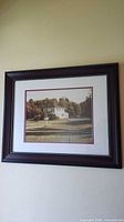 Wood-framed photograph of house with matting and beaded inner edge