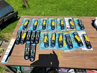 All 21 sealed Jensen remote controls laid out on table