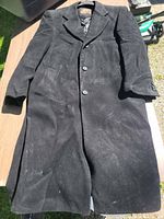 Full view front of black car coat laid flat showing overall style and length.