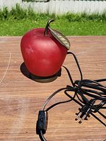 Full view of red glass apple lamp with cord