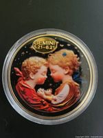 Front side of token showing enameled Gemini design inside capsule