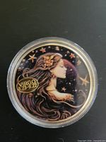 Obverse of Virgo token showing enameled female figure and date range