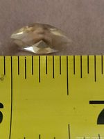 Side view of citrine on ruler showing length and pavilion facets