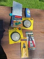 All items laid out: mop, cleaner bottle, two touch lamps, cutter, wire stripper