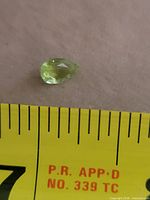 Gemstone beside tape for scale