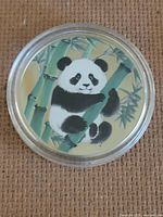 Obverse of enameled Panda token in capsule
