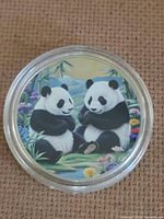 Obverse showing color-enameled pandas scene in capsule