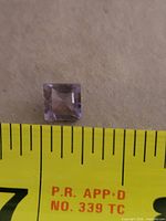 Square amethyst on ruler showing approx 6 mm size