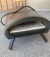 Front three-quarter view showing arched opening, stone, and foldable legs