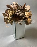Full view of mirrored vase and dried floral top