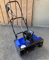 Full view of SnowJoe blue electric snow blower with handle folded upright
