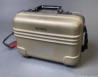 Front and side view of Sony beige hard shell case with handle and strap