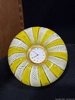 Front view showing yellow and white spiral Murano glass paperweight with clock