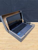 Laptop open in box with charger visible