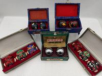 Group shot of all five open boxes showing Baoding balls and mask sets
