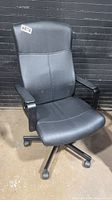 Front view of black faux leather office chair showing overall design and condition