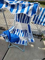 Folding chair unfolded showing canopy, seat, frame, bag, and striped fabric