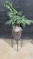 Full view of ceramic vase in metal stand with faux greenery