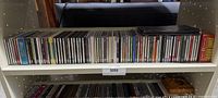 Full view of the shelf showing the row of CDs