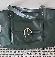 Front view of forest green Coach leather tote showing flap pocket, buckle detail, straps and gold hardware