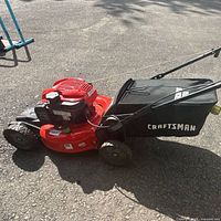 Left side view of Craftsman red mower with black Dust Blocker bag attached