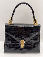 front view showing croc pattern, turn-lock clasp, gold-tone hardware