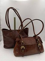 Both brown leather handbags side by side