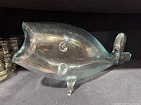 Side view of blown glass fish vase showing overall shape and tint