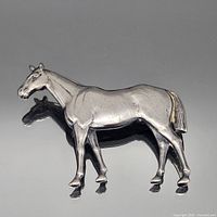 Front view of silver-tone standing horse brooch