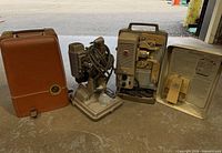 Group shot of projector, Revere accessory, case and open lid with splicer