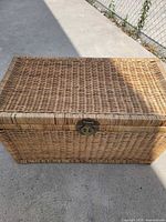 Top and front view of rectangular wicker chest with brass latch