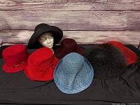 All seven hats arranged front and back rows