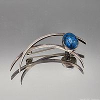 Front view of sterling silver modernist brooch showing turquoise stone and arched design