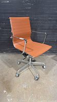 Full view of chair showing upholstery, arms, base