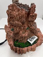 Full view of resin village fountain showing basin, marbles and power cord
