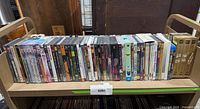 Full row of mixed DVDs, Blu-rays and CDs on cart shelf