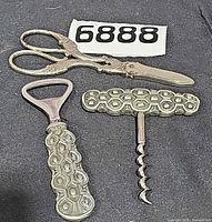 Scissors, bottle opener, corkscrew laid out
