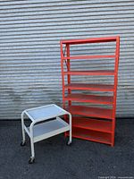 Shelving unit standing with utility cart beside it