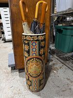 Full view of umbrella stand with umbrellas inside